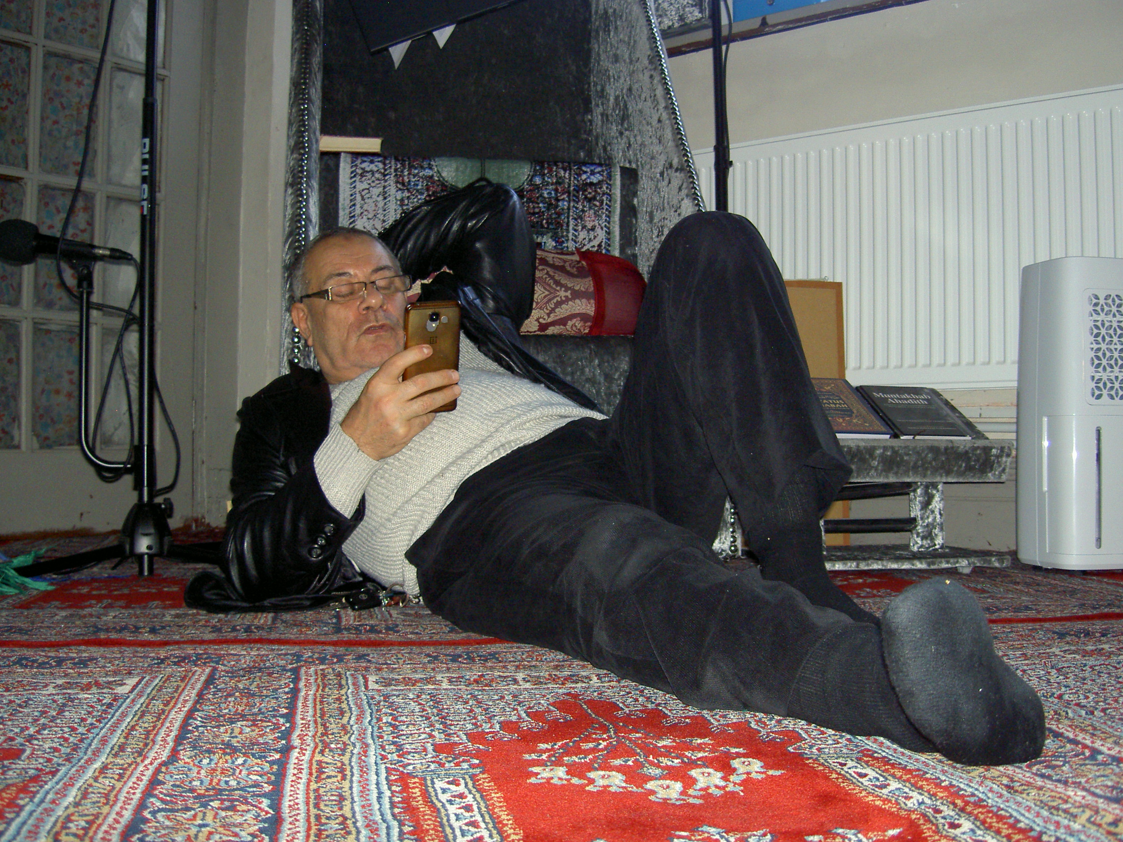Man lying on the floor looking at his phone